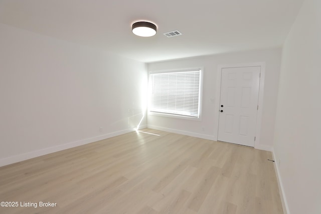 spare room with baseboards, visible vents, and light wood-style floors