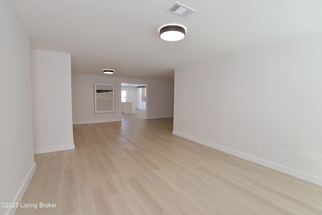 spare room with light wood-style floors, baseboards, and visible vents