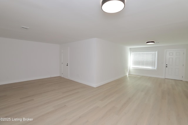 unfurnished room with light wood-type flooring and baseboards