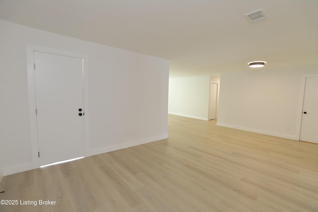 spare room featuring light wood finished floors, baseboards, and visible vents