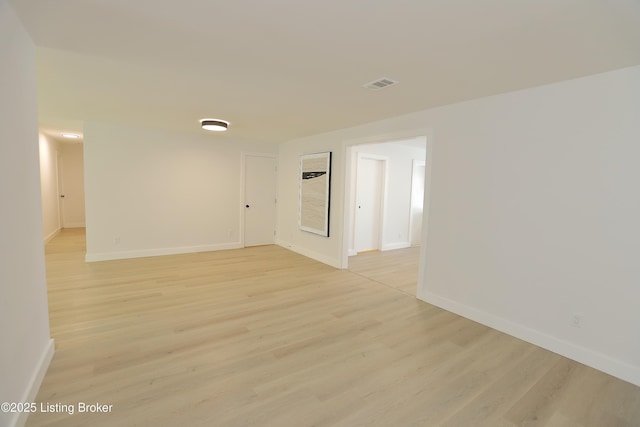 unfurnished room with light wood-style floors, baseboards, and visible vents