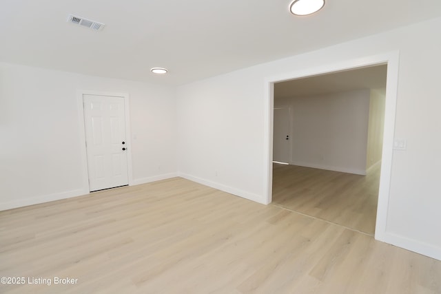 spare room with light wood-style floors, baseboards, and visible vents