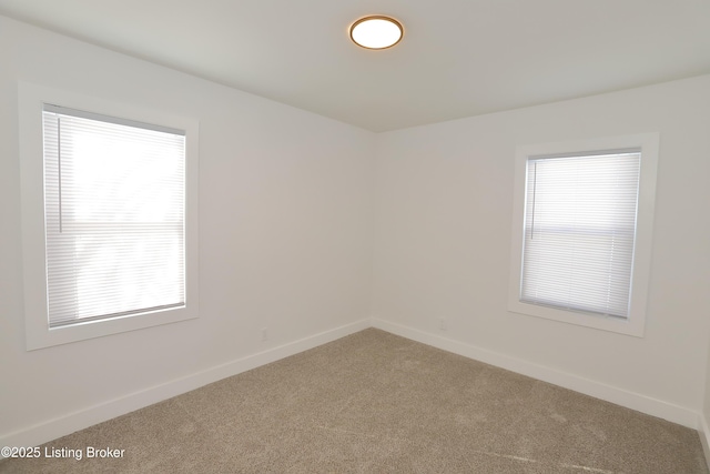 carpeted spare room with a wealth of natural light and baseboards