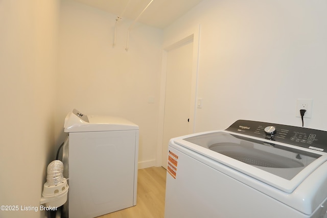 laundry area featuring laundry area, washer and clothes dryer, and light wood-type flooring