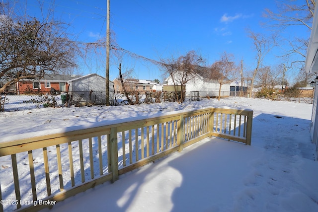 yard covered in snow featuring a residential view and fence