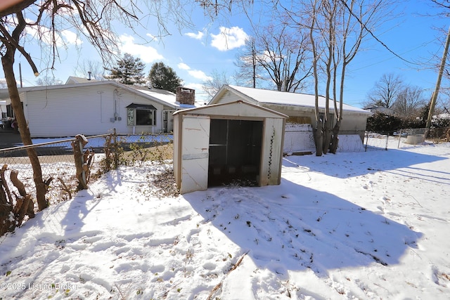 exterior space featuring a carport, fence, a detached garage, and a shed