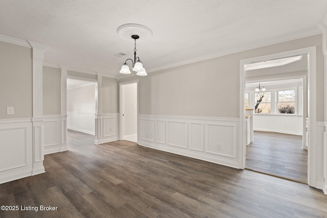 unfurnished dining area featuring crown molding, dark wood-style flooring, and a notable chandelier