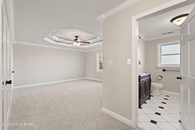 bathroom featuring visible vents, a ceiling fan, baseboards, ornamental molding, and a raised ceiling