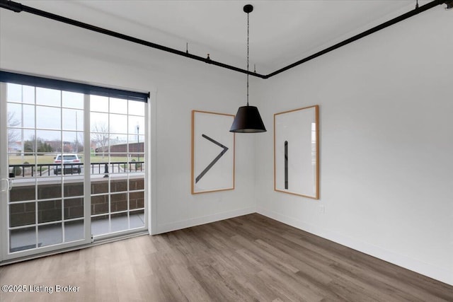 unfurnished room featuring crown molding, wood finished floors, and baseboards