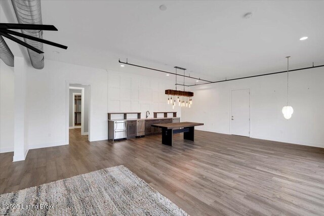 rec room featuring a sink, baseboards, and wood finished floors