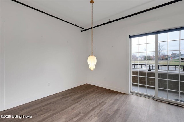 spare room featuring wood finished floors and baseboards