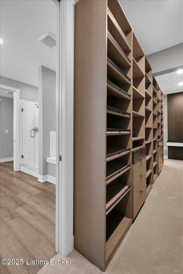 walk in closet featuring visible vents and wood finished floors