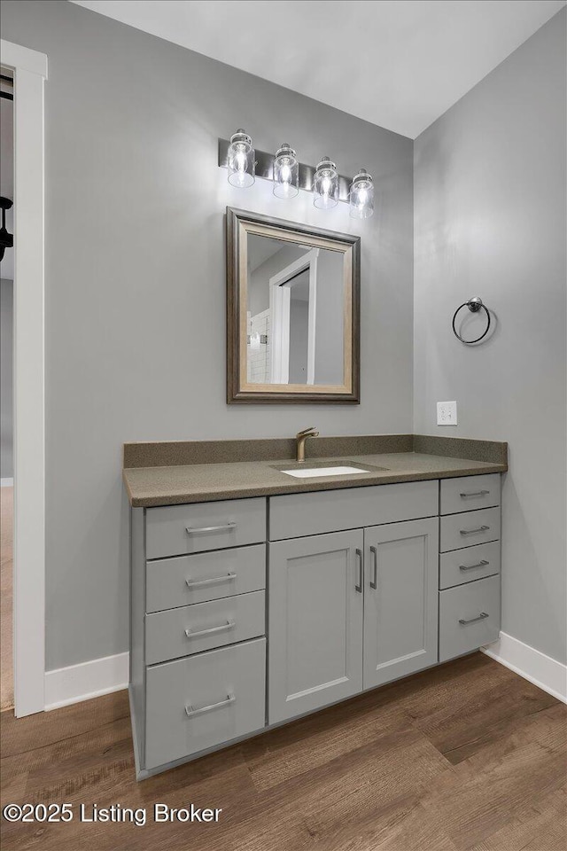 bathroom with vanity, baseboards, and wood finished floors