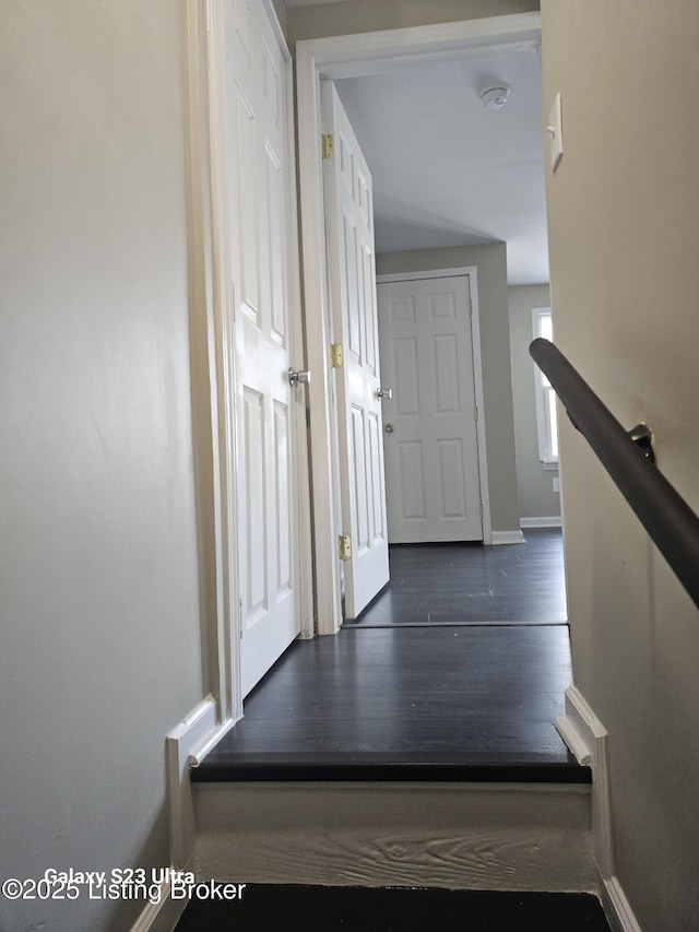 staircase with baseboards and wood finished floors