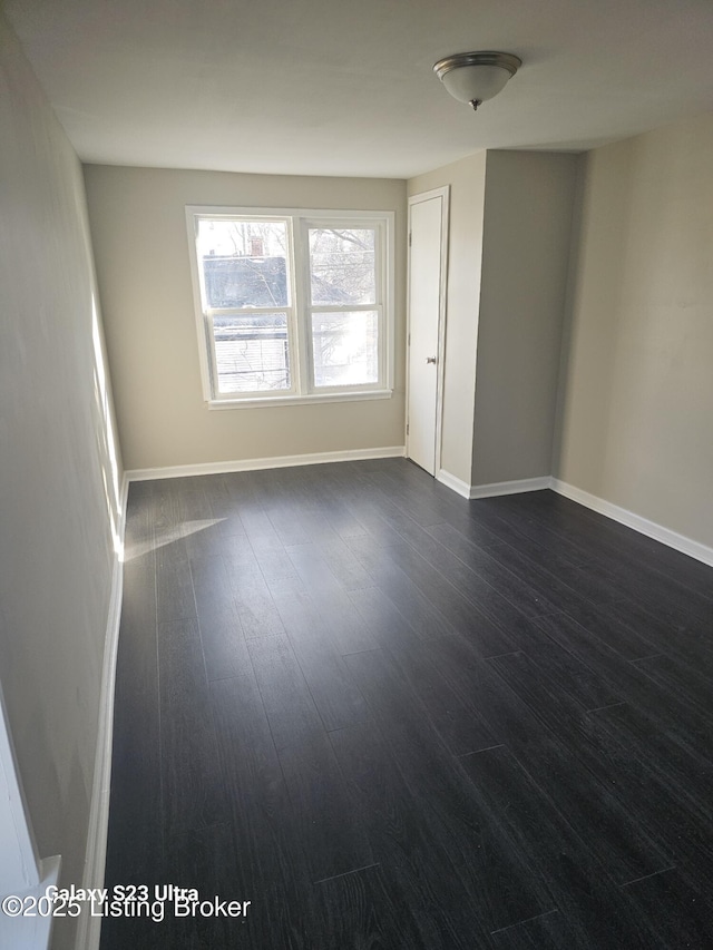 empty room featuring dark wood finished floors and baseboards