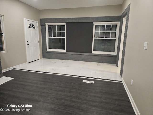 foyer with baseboards and wood finished floors