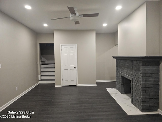 unfurnished living room featuring dark wood-style floors, a fireplace, recessed lighting, stairway, and baseboards