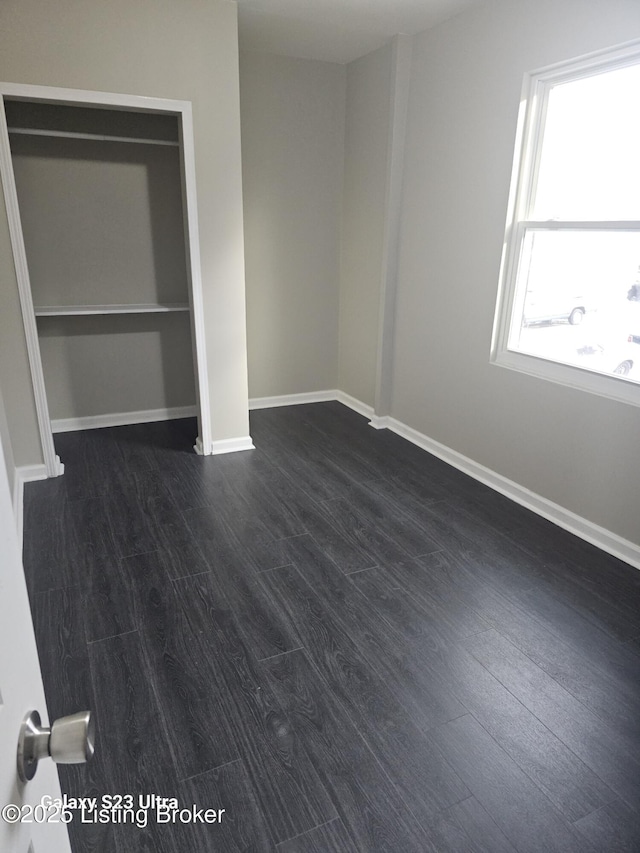 unfurnished bedroom featuring dark wood-style floors and baseboards