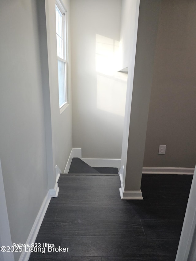 staircase featuring baseboards and wood finished floors