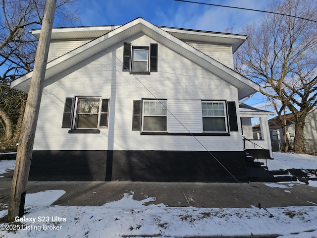 view of snowy exterior with brick siding