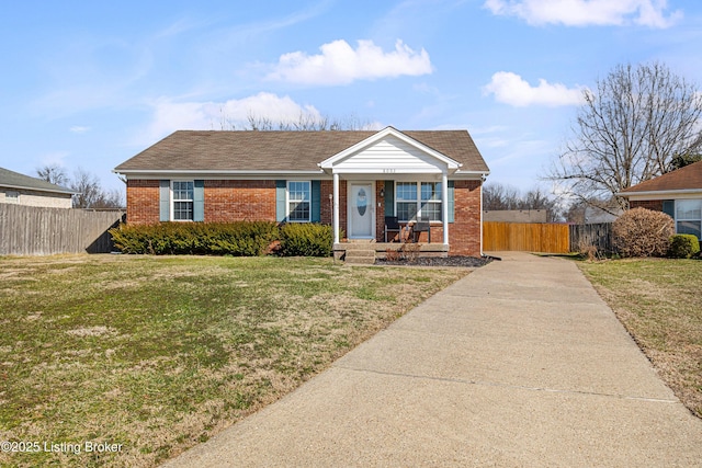 view of front of home featuring a front yard, fence, and brick siding