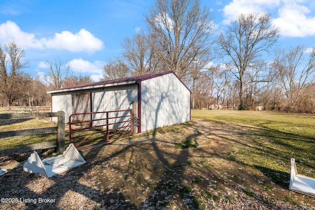 view of pole building with a lawn and fence