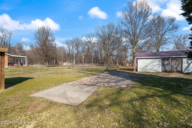 view of yard featuring an outdoor structure, fence, and an outbuilding