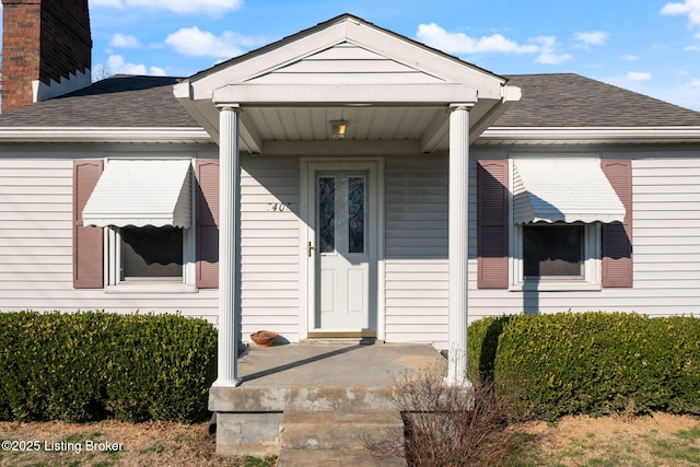 entrance to property featuring roof with shingles