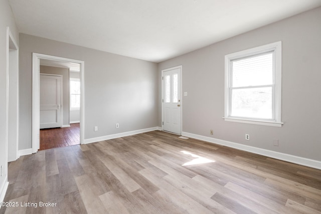 unfurnished room featuring light wood-type flooring and baseboards