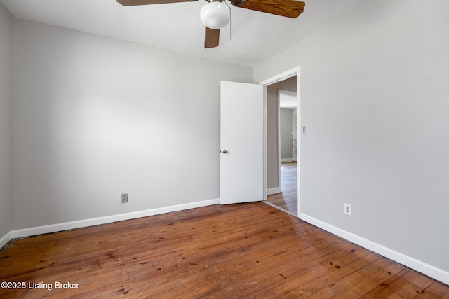 unfurnished room with baseboards, a ceiling fan, and hardwood / wood-style flooring