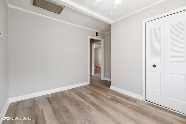 unfurnished bedroom with wood finished floors, baseboards, ceiling fan, ornamental molding, and a closet