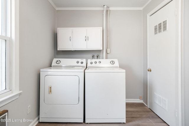 clothes washing area featuring visible vents, ornamental molding, cabinet space, separate washer and dryer, and light wood finished floors