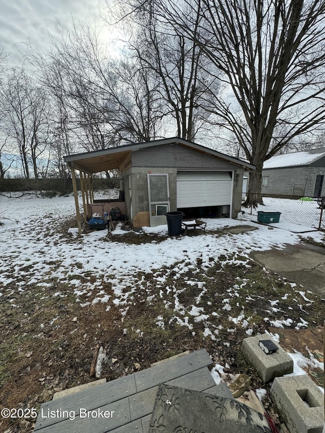 exterior space featuring a garage, a carport, and concrete block siding