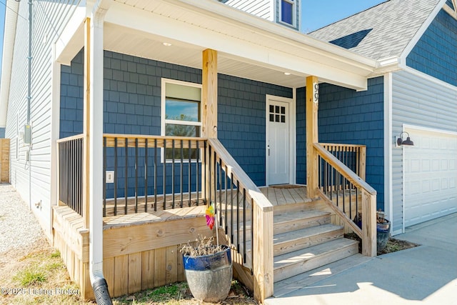 entrance to property with covered porch, a shingled roof, and an attached garage