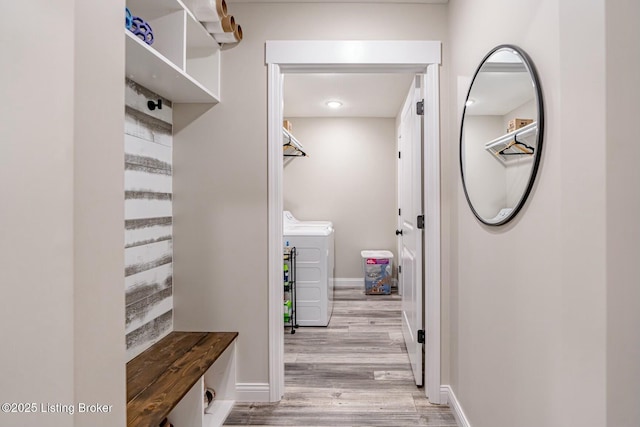 mudroom with washer and dryer, baseboards, and light wood finished floors