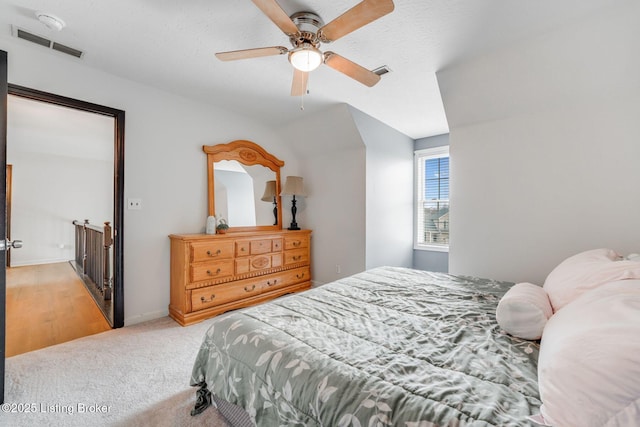 bedroom with baseboards, visible vents, a ceiling fan, and light colored carpet