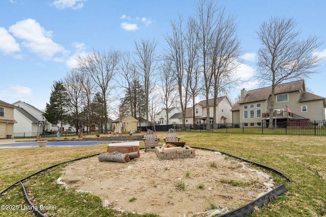 view of yard with an outdoor fire pit, a residential view, and fence