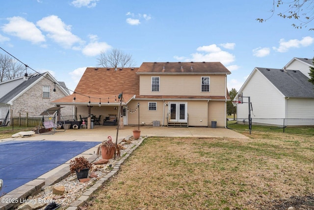 back of house with a yard, french doors, a fenced backyard, and a patio