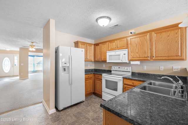 kitchen with dark countertops, visible vents, light carpet, a sink, and white appliances