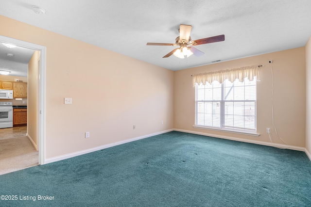 carpeted spare room with visible vents, ceiling fan, a textured ceiling, and baseboards