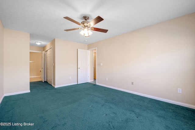 carpeted empty room with a ceiling fan and baseboards