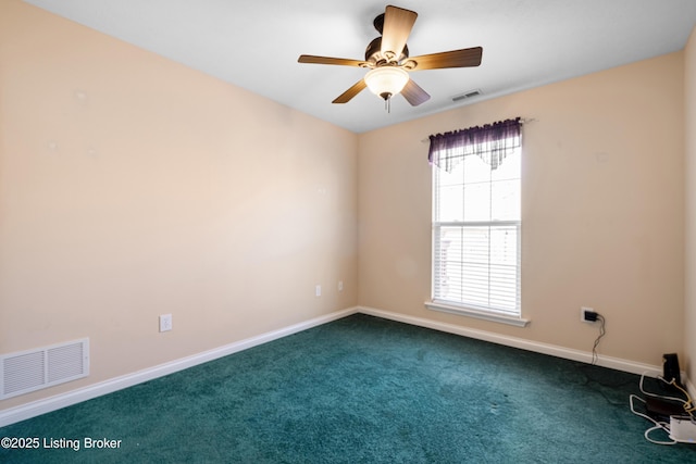 spare room featuring a ceiling fan, dark carpet, visible vents, and baseboards