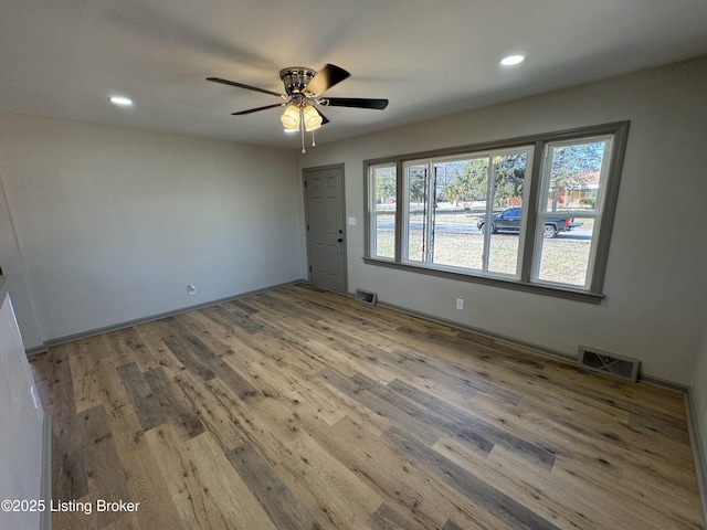 empty room featuring wood finished floors, visible vents, and recessed lighting