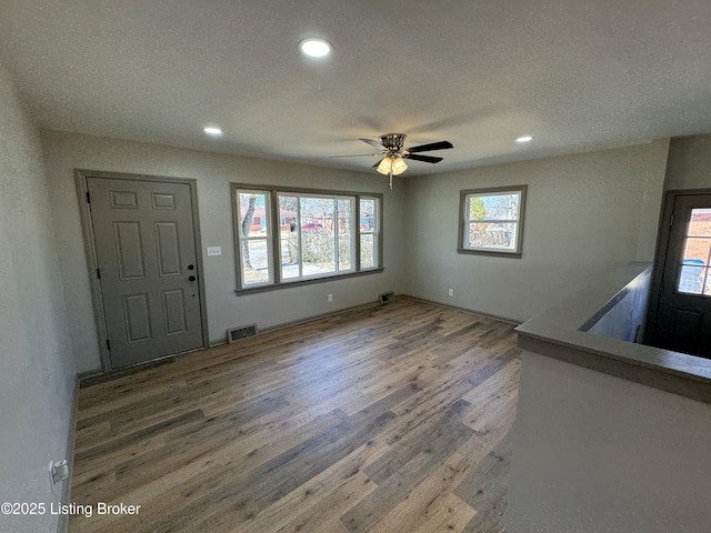 foyer with a ceiling fan, visible vents, wood finished floors, and recessed lighting