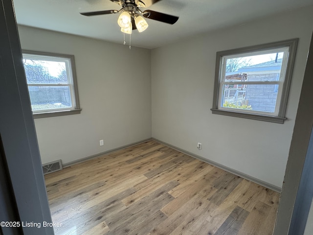 unfurnished room with light wood-type flooring, baseboards, visible vents, and a ceiling fan