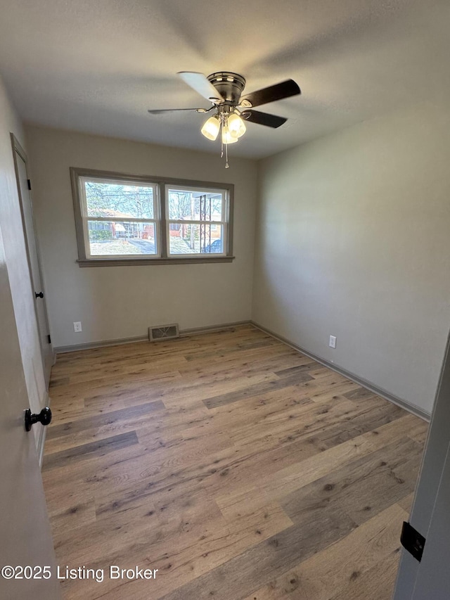 empty room with light wood-type flooring, visible vents, and ceiling fan