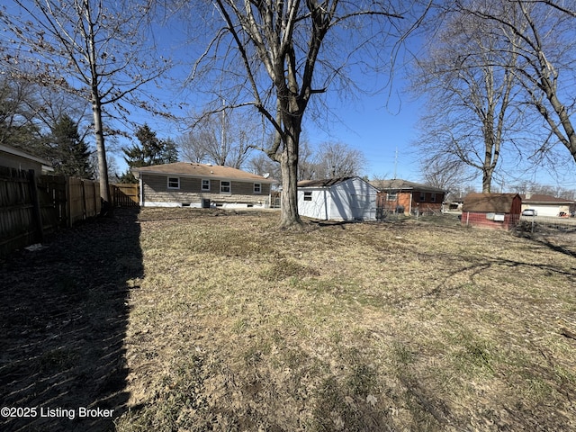 view of yard with a shed, fence, and an outdoor structure