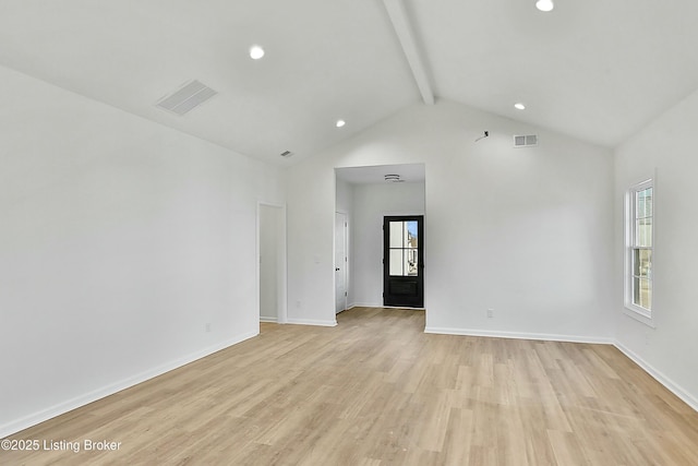 spare room featuring baseboards, light wood-style flooring, visible vents, and beam ceiling