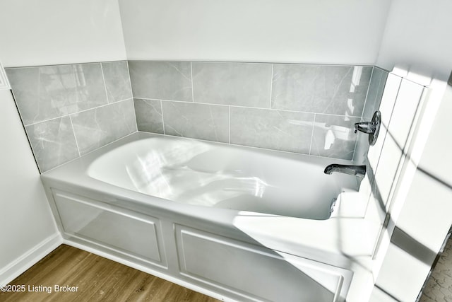 full bathroom featuring a bath and wood finished floors