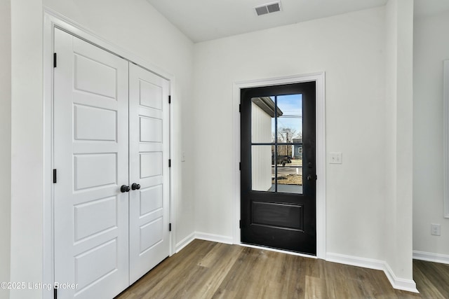 foyer with visible vents, baseboards, and wood finished floors